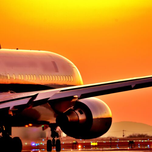 美しい夕焼け空・夕日を背景に飛行機(アップ)